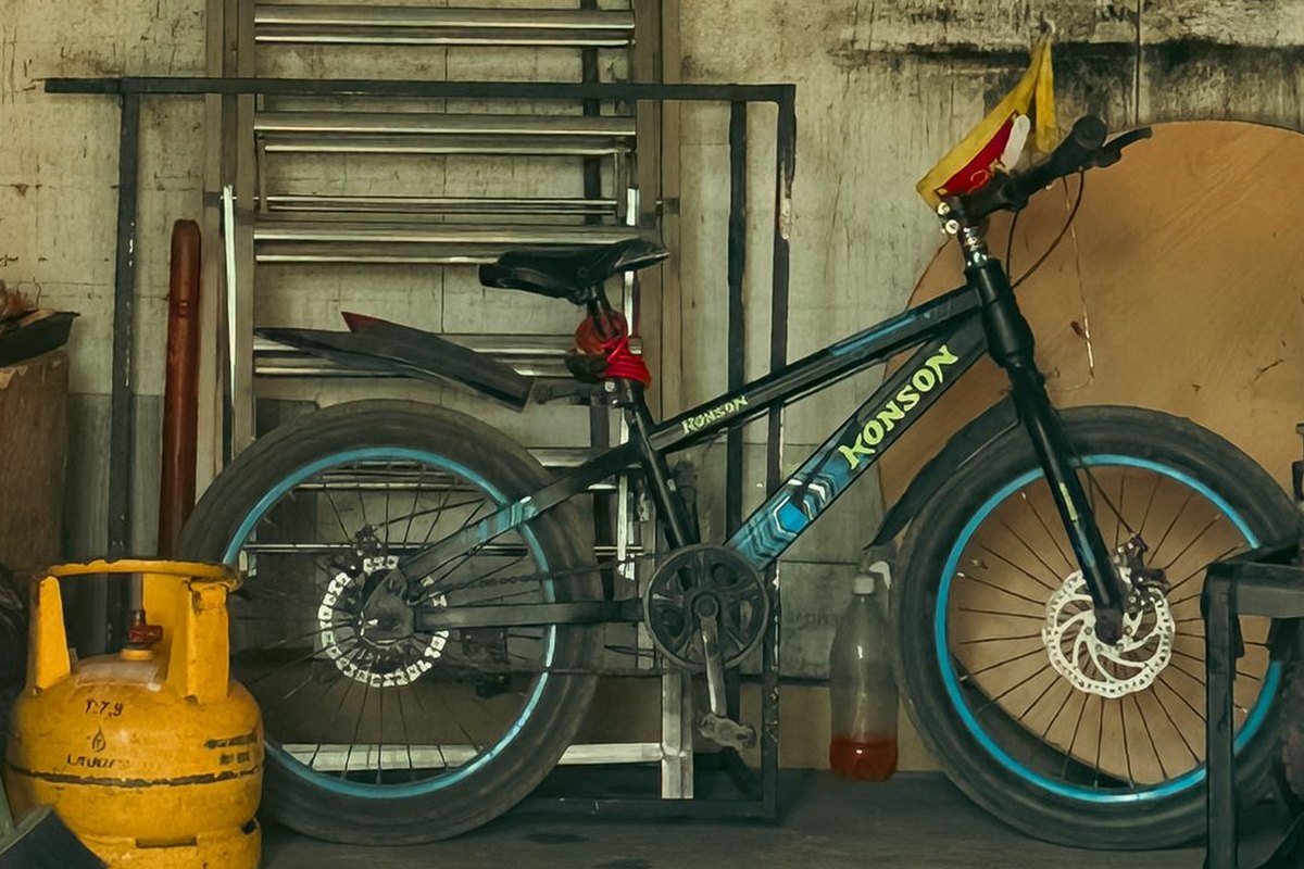 Black kids bicycle leaning on a steel rack beside a yellow gas cylinder and a ladder in a small storage room